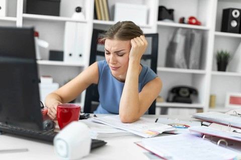 Beautiful young girl in a blue dress is working in the office. photo with depth of field