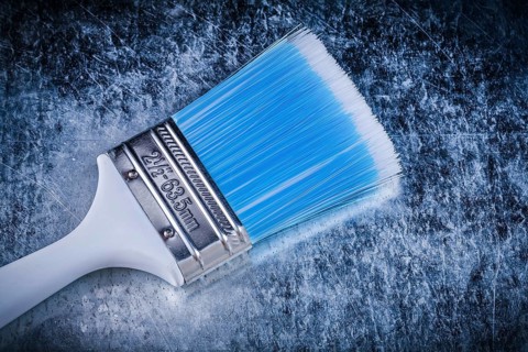 Paint brush on scratched metallic background construction concept