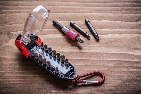 Toolbox with interchangeable stainless screwdriver heads on wooden board