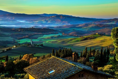 Predawn dusk. The sky is turning pink over the hills. Picturesque valley in central Italy. Tuscany.