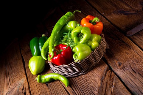 Verschiedene geernte paprika und scharfe paprika im korb