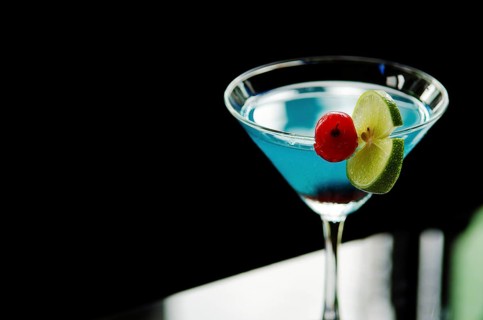 Blue cocktail drink with cherry and lime