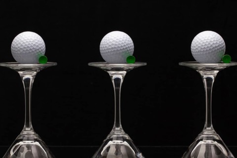 Three glasses of champagne with golf balls