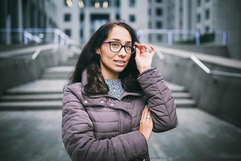 Portrait beautiful young business woman brunette in jacket and jumper stands on background office