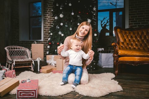 Young mother and son playing near Christmas tree. young mother and son playing near the Christmas