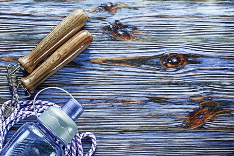 Jumping rope water shaker on blue vintage wooden board