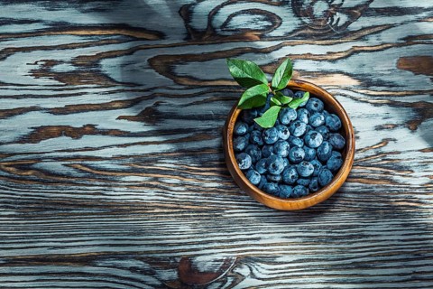 Ripe huckleberries in wooden bowl