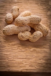 Small stack of peanuts on vintage wooden board food and drink concept