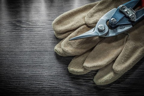 Safety gloves steel scissors on wooden board