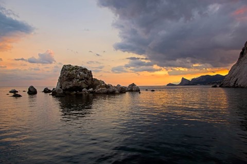 Sunset on the Black Sea coast. View from the embankment of Sudak in the direction of Novyy Svet.