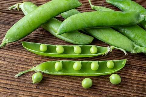 Few green peas on black background