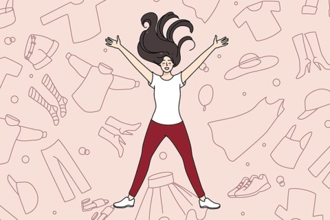 Overjoyed young girl lying among clothes excited with shopping and purchase. Smiling woman