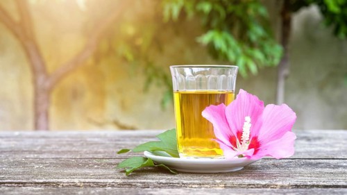 A mallow tea with blossom on old wooden background
