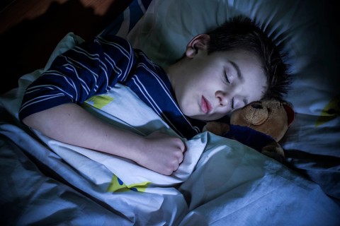 Sleeping child with his toy bear