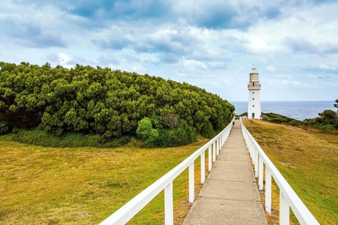 Magnificent lighthouse on the ocean shore. The Great Ocean Road runs along the Pacific coast of