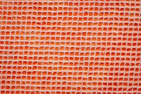 White Thai mulberry lace paper with a grid pattern against orange background