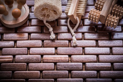 Wood peeling brush massagers and loofah on checked wooden place mat healthcare concept