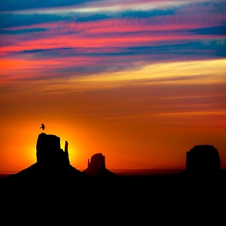 Sunrise at Monument Valley West and East Mittens and Merrick Butte with crow Utah