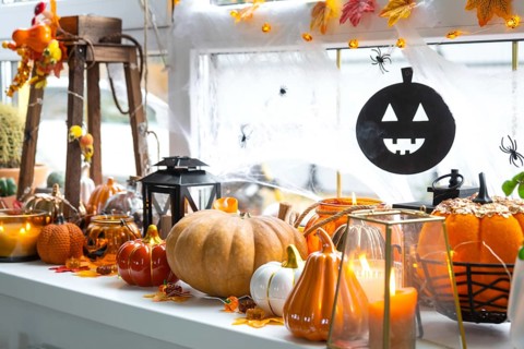 Festive decor of the house on the windowsill for Halloween, pumpkins, Jack o lanterns, skulls,