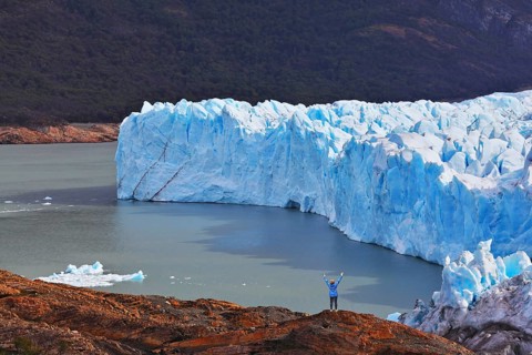 The woman - tourist admire the white-blue icy splendor. Giant lake Perito Moreno glacier