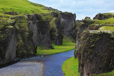 Iceland in the summer. Canyon Fjadrargljufur and cold fast river with a pebble bottom