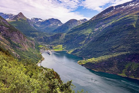 The largest, most beautiful and famous Norwegian fjord Geiranger. Snow-white ocean liner is moored