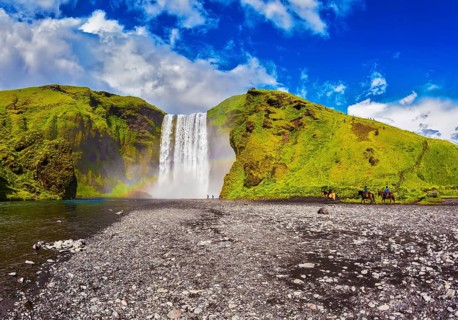 Huge waterfall flowing from under giant glacier. Iceland, waterfall Skogafoss summer, clouds of