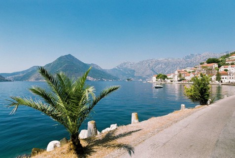 Ancient buildings of Perast on the embankment at the foot of the mountains.