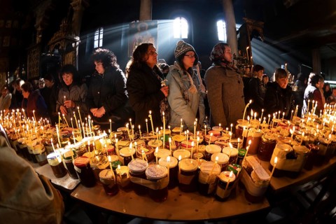 Blagoevgrad, Bulgaria - February 10, 2019: Worshippers light candles on jars with honey during a