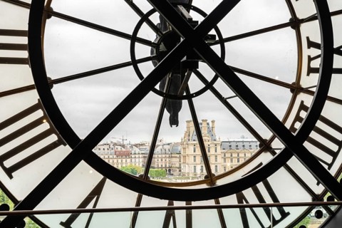 View of the Louvre through a large Clock from Museum d'Orsay in Paris, France, Europe