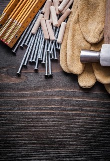Wooden meter heap of dowels claw hammer brown protective gloves and metal nails on vintage wood