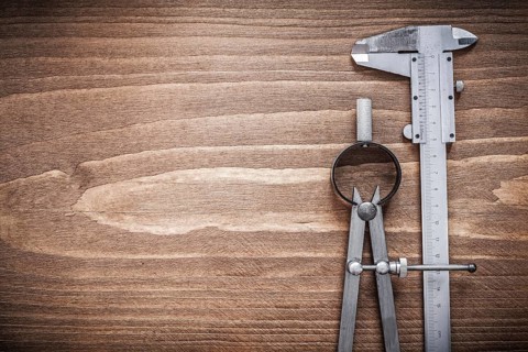 Slide caliper divider on wooden board copyspace construction concept