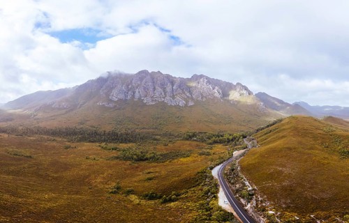 An aerial view of Gordon River Rd at the Sentinel range of mountains near Bitumen Bones Sculpture