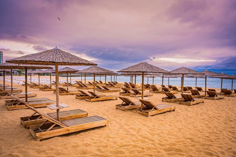The beach has sunbeds and bamboo parasols and appears quiet and deserted when the sky is cloudy,