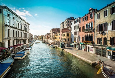 Ancient buildings and boats in the channel in Venice
