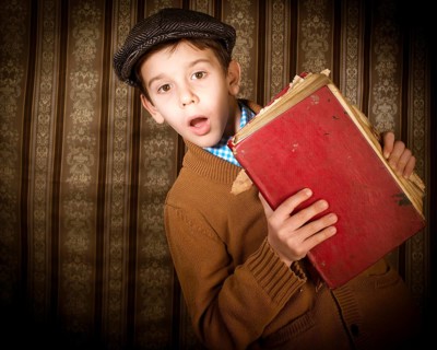Child with red vintage book. Vintage clothes and hat