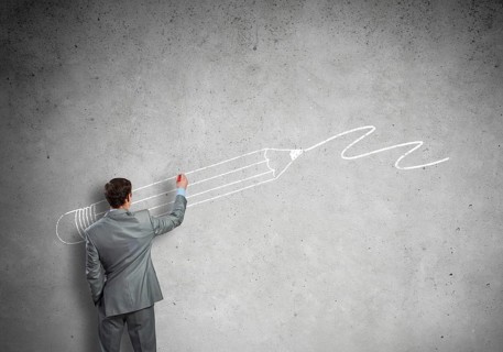 Rear view of businessman drawing sketches on wall