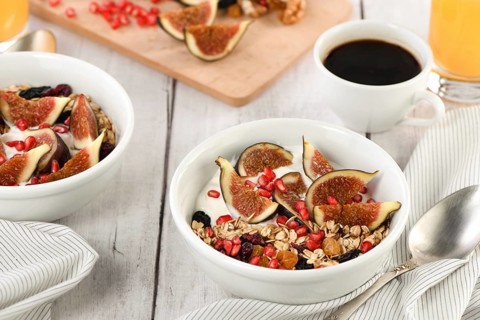 Healthy and delicious breakfast. Oatmeal muesli with Greek yogurt, fresh figs, dried fruits and