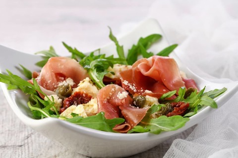 Arugula salad, prosciutto with sun-dried tomatoes, slices of mozzarella, capers, seasoned with