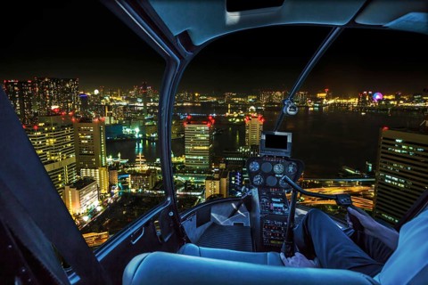 Helicopter flying over Tokyo cityscape, the Bay area with its bridges and Odaiba by night from