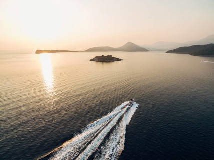 Motor boat sails to the Mamula fortress on the island. Kotor Bay.