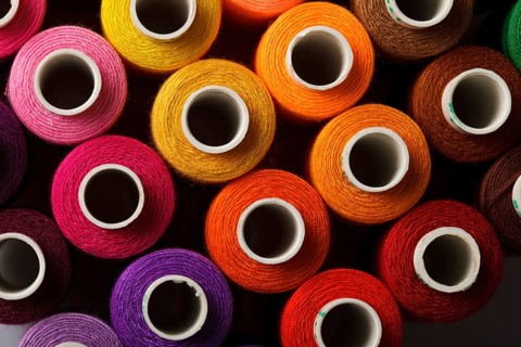 Sewing threads multicolored background closeup