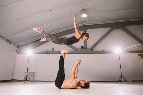 Young couple Couple practicing acro yoga in gym. Healthy lifestyle. Acroyoga. Couple yoga. Partner