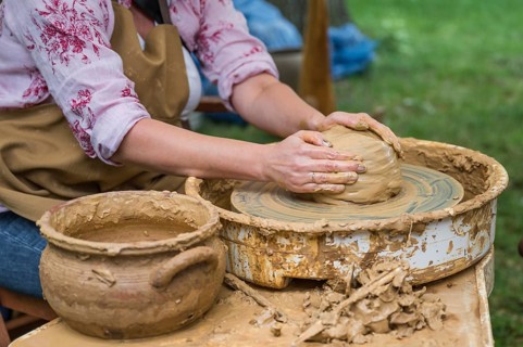 Hands of a woman making a clay pot on a potter's wheel in Boleslawiec, Poland, Europe