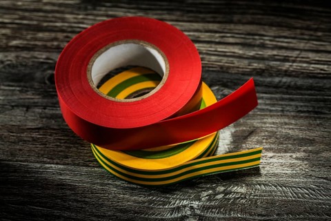 Set of insulating tapes on wooden board