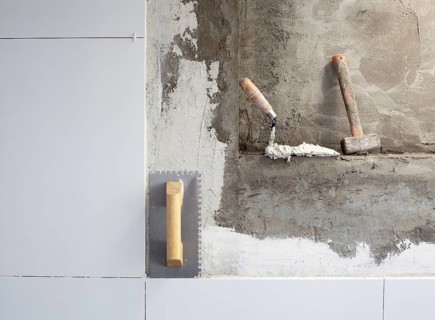 Construction tools notched trowel on tiles mortar wall