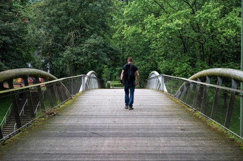 Man walking over a pedestrian bridge at Peterbos, Anderlecht, Brussels Capital Region, Belgium.
