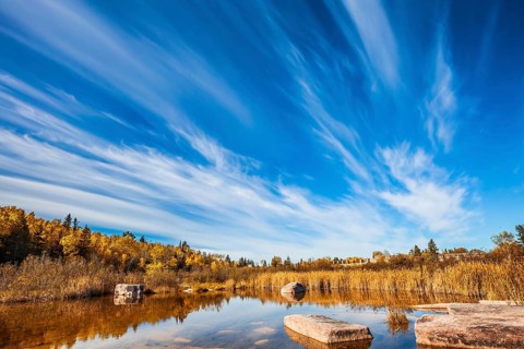Wonderful autumn day. Indian summer in Manitoba, Canada. Cirrus clouds are reflected in the