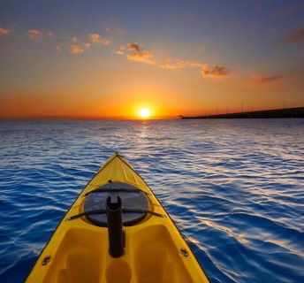 Kayak sailing in ocean sea at sunset or sunrise