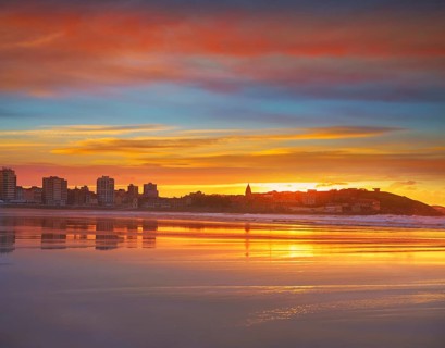 Gijon skyline sunset in San Lorenzo beach of Asturias in Spain